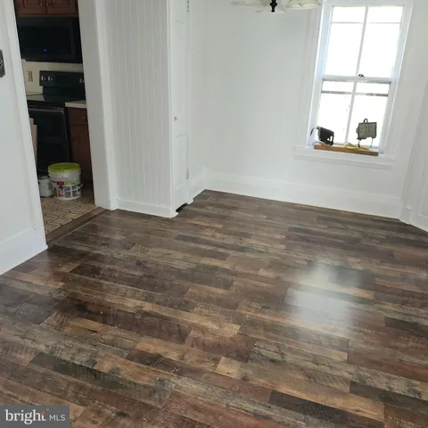 an empty room with windows and wooden floor