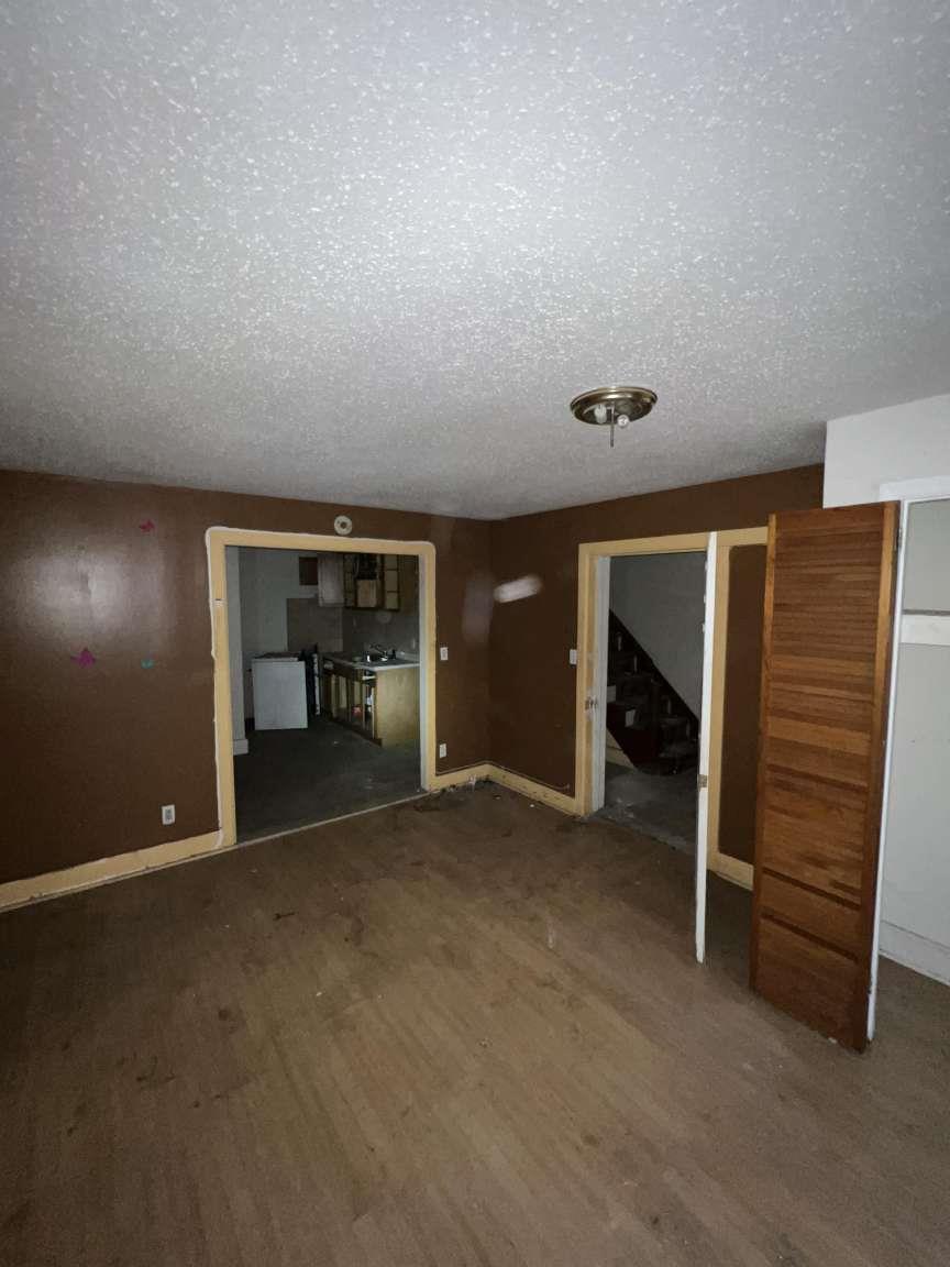 1430 Pacific Street Brooklyn, NY 11216 - Photo 8 of 24 Unfurnished living room with dark hardwood / wood-style flooring and a textured ceiling