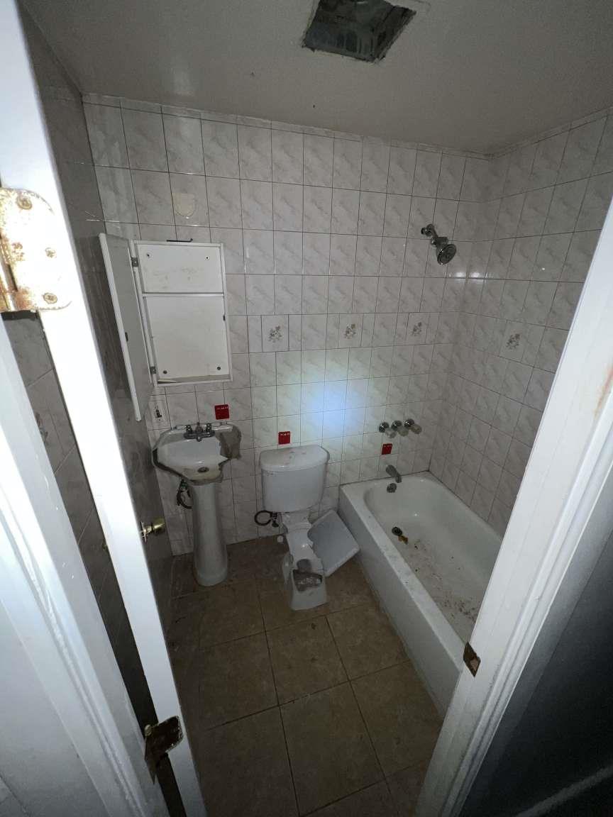 1430 Pacific Street Brooklyn, NY 11216 - Photo 10 of 24 Full bathroom featuring toilet, sink, tile walls, tiled shower / bath combo, and tile patterned flooring
