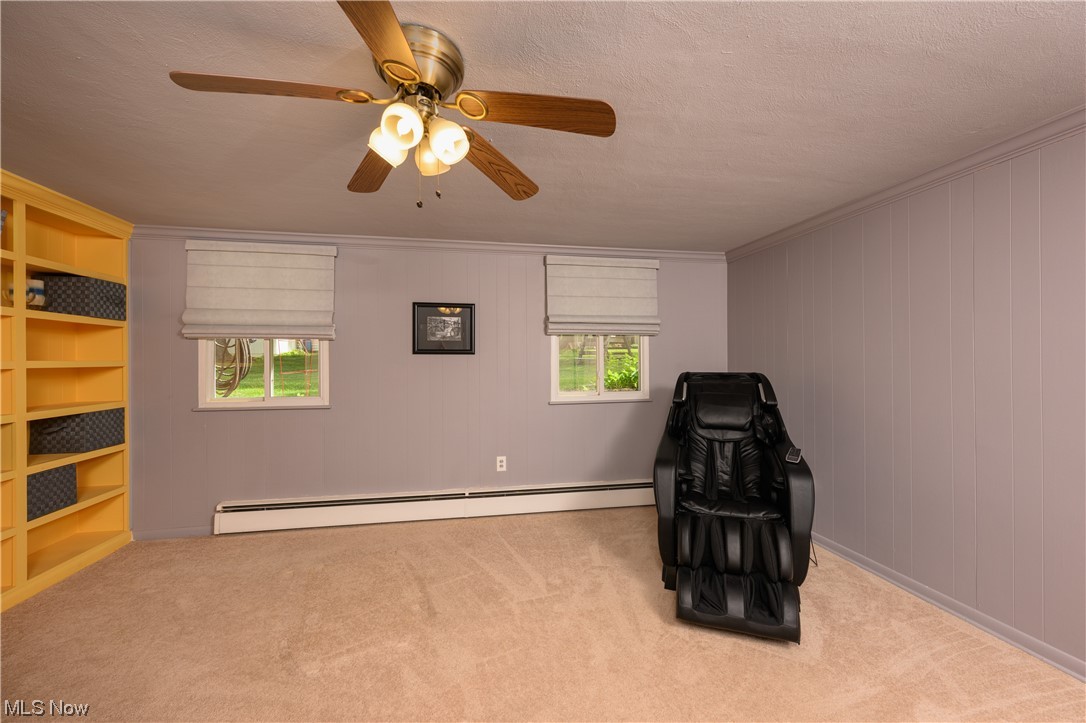 572 Overwood Road Akron, OH 44313 - Photo 14 of 35 Family room or study area with a textured ceiling, crown molding, a baseboard radiator,
Family rm/study and
a wealth of natural light, light carpet, and ceiling fan