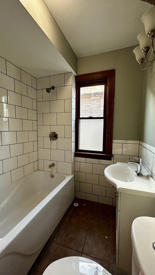 8406 South Brandon Avenue, Unit 2 Chicago, IL 60617 - Photo 5 of 9 a bathroom with a tub sink and mirror