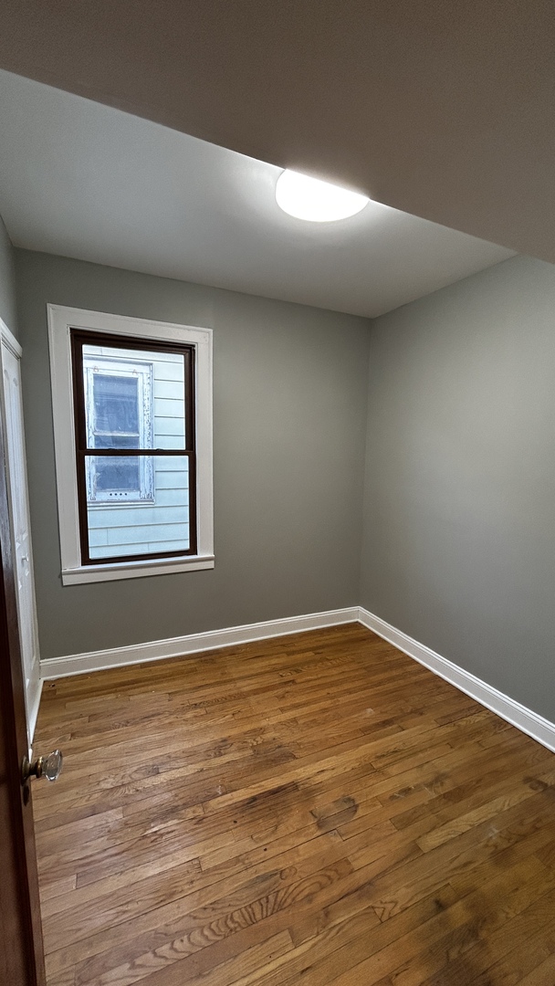 8406 South Brandon Avenue, Unit 2 Chicago, IL 60617 - Photo 6 of 9 a view of an empty room with window and wooden floor