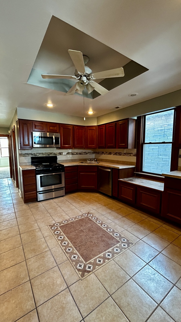 8406 South Brandon Avenue, Unit 2 Chicago, IL 60617 - Photo 8 of 9 a open kitchen with stainless steel appliances granite countertop a sink and a stove