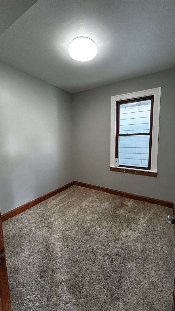 8406 South Brandon Avenue, Unit 2 Chicago, IL 60617 - Photo 9 of 9 an empty room with a empty space and windows