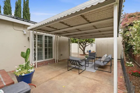 a view of a patio with chairs and potted plants