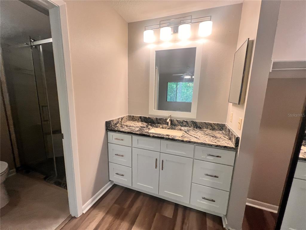 17 Escondido Circle, Unit 239 Altamonte Springs, FL 32701 - Photo 18 of 30 a bathroom with a granite countertop sink and mirror