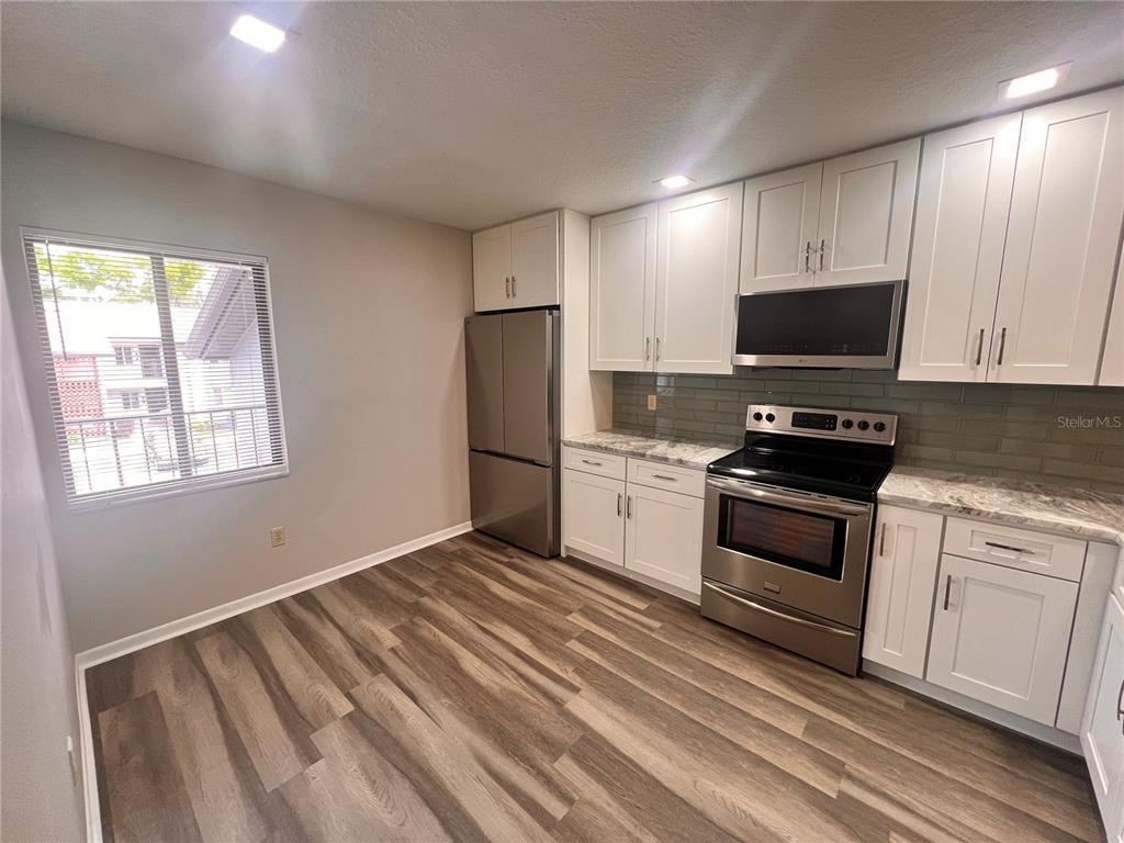 17 Escondido Circle, Unit 239 Altamonte Springs, FL 32701 - Photo 3 of 30 a kitchen with granite countertop a refrigerator and a stove top oven