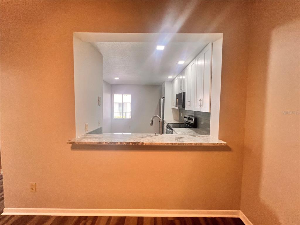17 Escondido Circle, Unit 239 Altamonte Springs, FL 32701 - Photo 10 of 30 a view of living room with granite countertop furniture and a flat screen tv