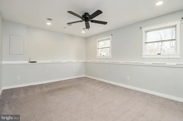an empty room with a window and a ceiling fan