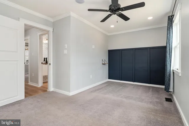 an empty room with a window and a fan
