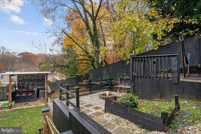 a view of a roof deck with wooden fence and a bench