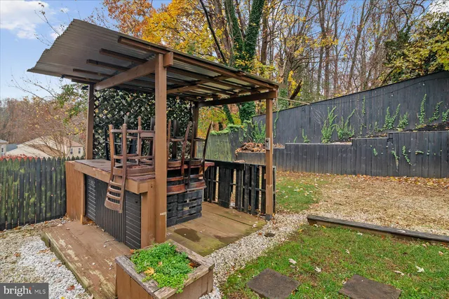 a view of a roof deck with wooden fence and a bench