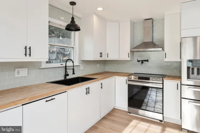 a kitchen with stainless steel appliances granite countertop a sink a stove and cabinets