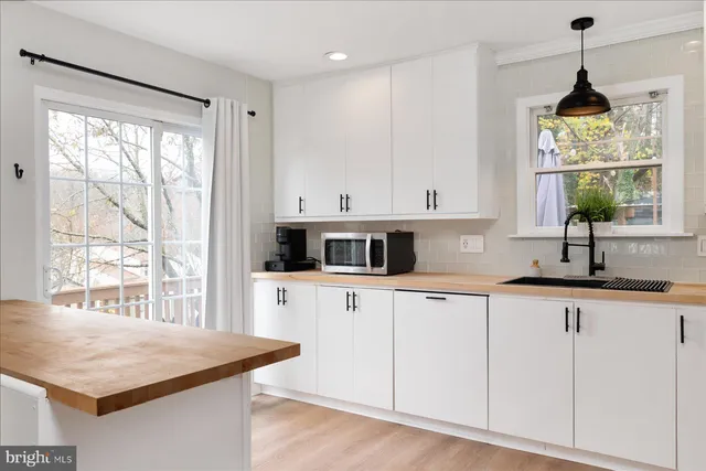 a kitchen with stainless steel appliances granite countertop a stove a sink and white cabinets