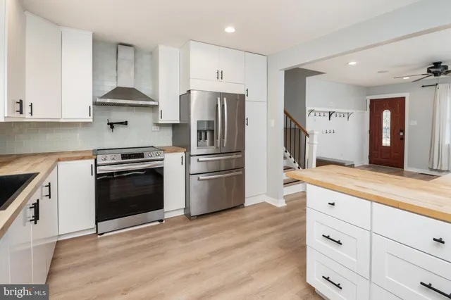 a kitchen with white cabinets and stainless steel appliances