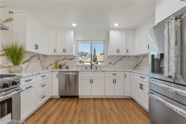 a kitchen with kitchen island granite countertop white cabinets and stainless steel appliances