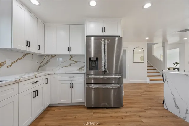 a large kitchen with stainless steel appliances granite countertop a stove a sink and a refrigerator