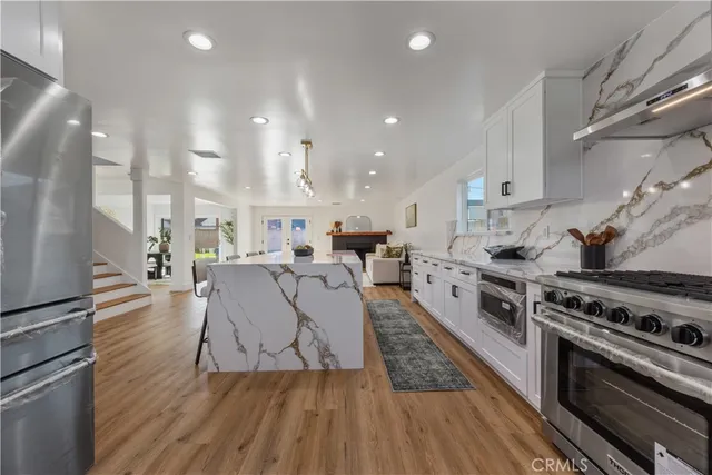 a kitchen with stainless steel appliances kitchen island granite countertop a refrigerator and a sink