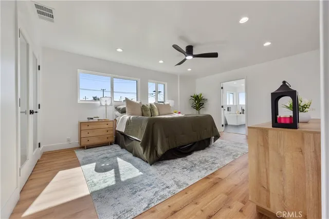 a bedroom with a large bed and a potted plant