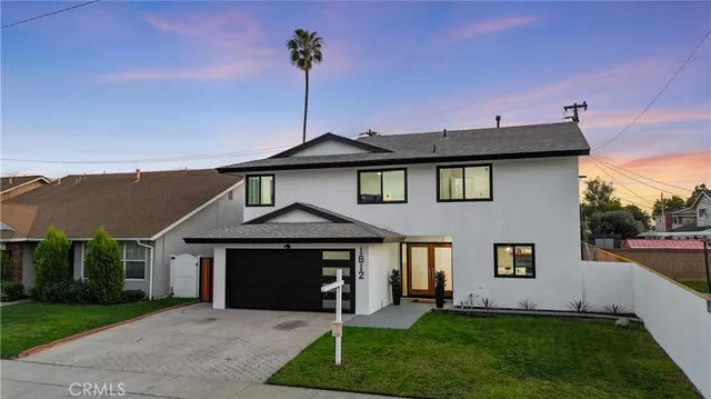 a front view of a house with a garden and yard