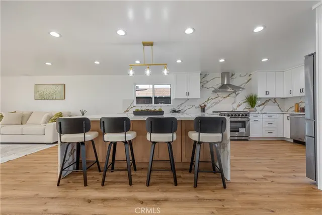 a kitchen with stainless steel appliances granite countertop a stove and white cabinets