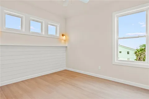 a view of empty room with wooden floor and cabinet