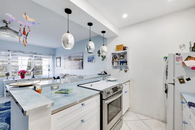 a kitchen that has a lot of cabinets and wooden floor