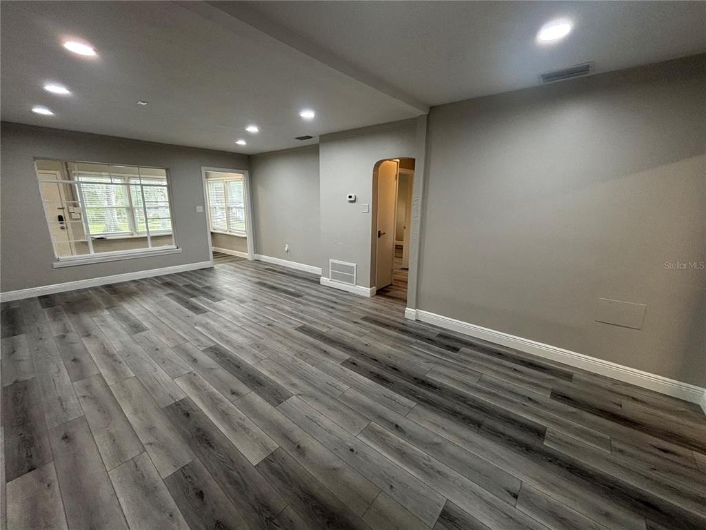 237 Northeast 11th Avenue Ocala, FL 34470 - Photo 2 of 17 an empty room with wooden floor and windows