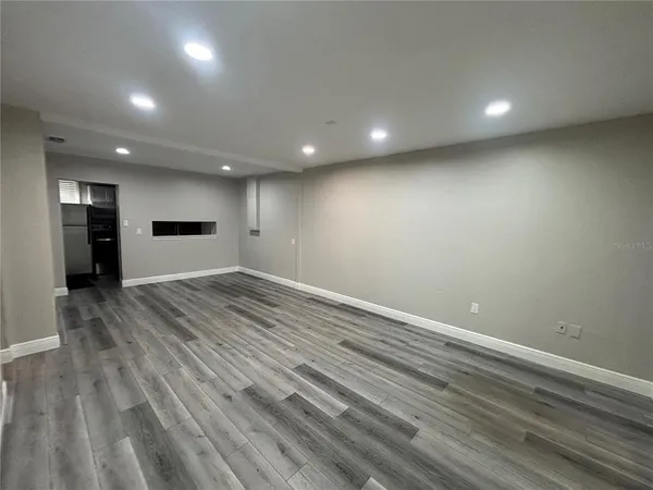 an empty room with wooden floor and a window