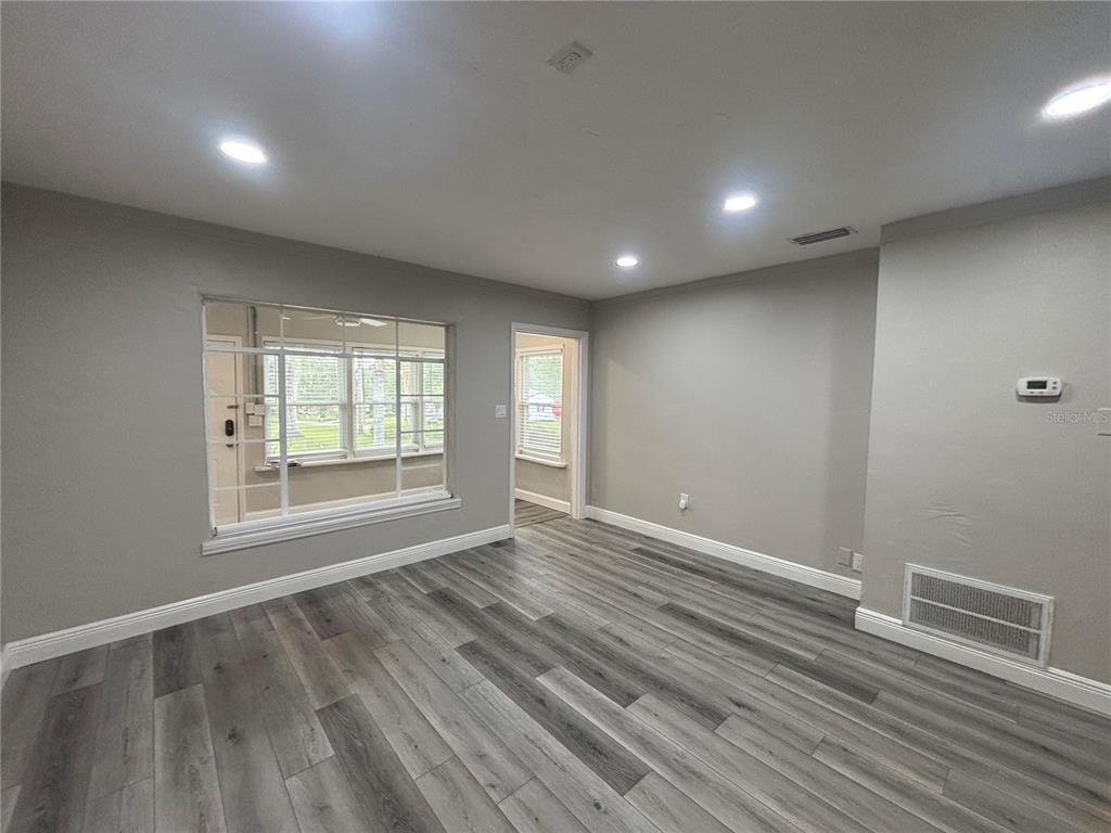237 Northeast 11th Avenue Ocala, FL 34470 - Photo 5 of 17 an empty room with wooden floor and windows