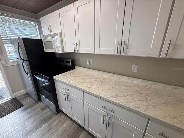 a kitchen with granite countertop white cabinets and sink