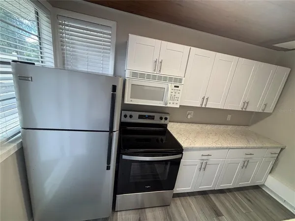 a kitchen with a white stove and white cabinets