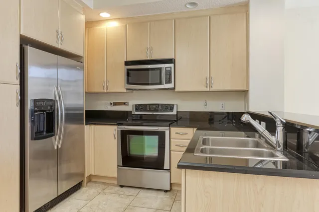 a kitchen with stainless steel appliances granite countertop a stove a microwave and a refrigerator