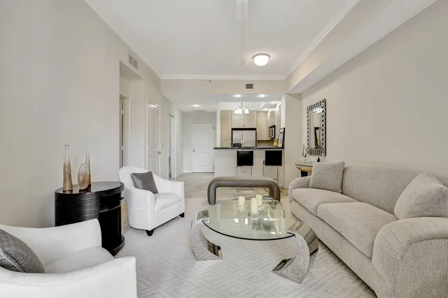a living room with furniture and a dining table with kitchen view