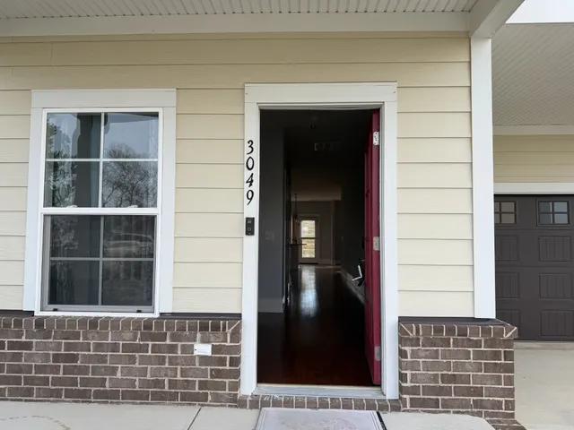 a view of a kitchen with refrigerator and wooden floor