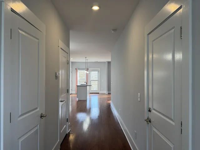 a kitchen with stainless steel appliances granite countertop a refrigerator a sink a stove and a wooden floors