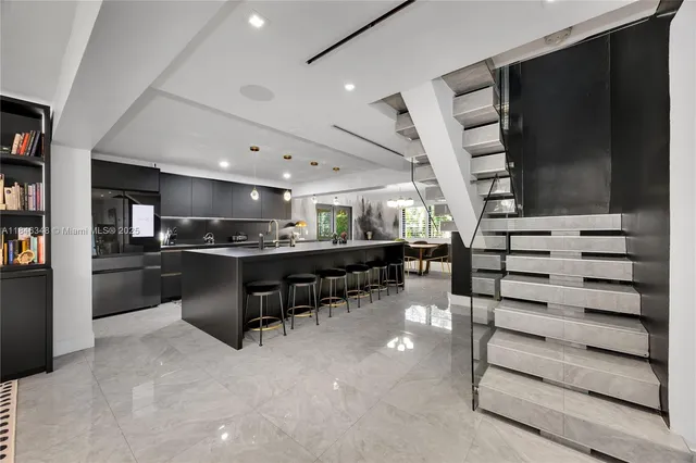 a kitchen with stainless steel appliances kitchen island granite countertop a refrigerator and a stove