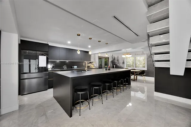 a kitchen with a dining table chairs and refrigerator