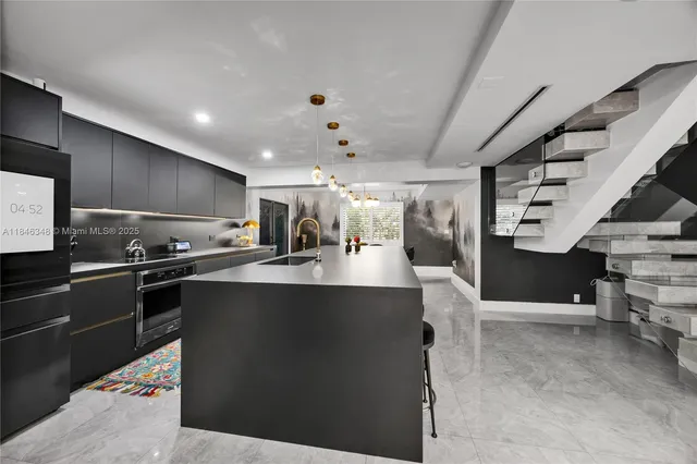 a kitchen with stainless steel appliances kitchen island granite countertop a refrigerator and a stove