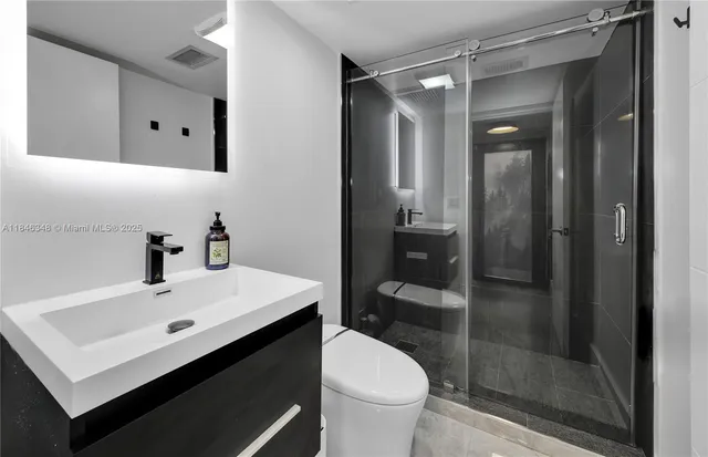 a bathroom with a sink mirror toilet and