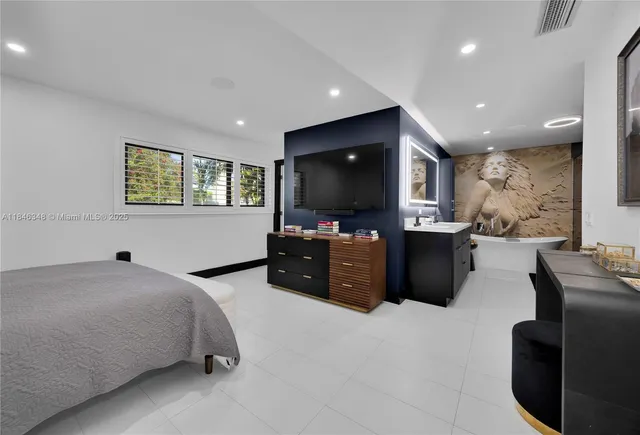 a bedroom with a bed and a flat screen television