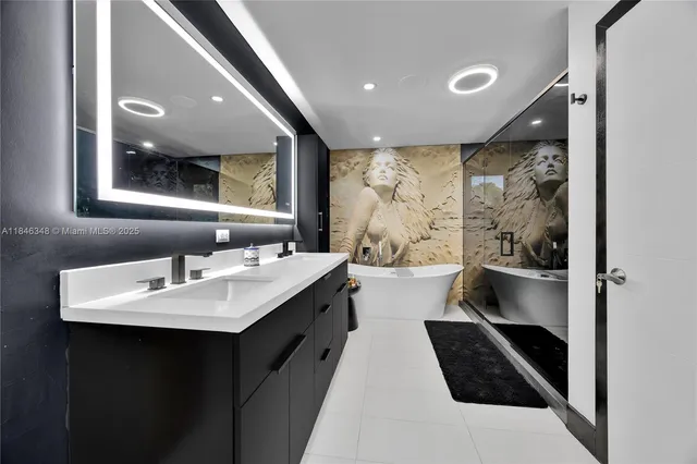 a en suite bathroom with a double vanity sink a toilet and a large mirror