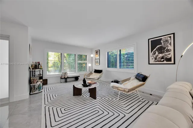 a living room with furniture large window and a table