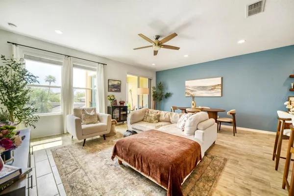 a spacious bedroom with a bed a couch and a large window