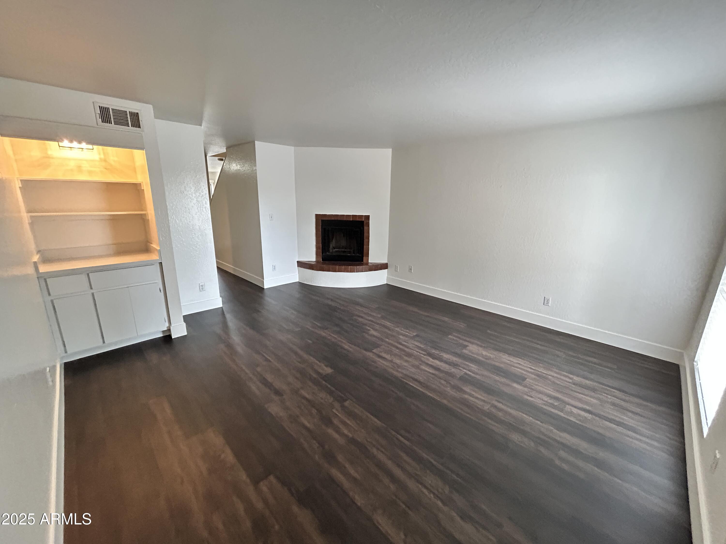 1702 East Ocotillo Road, Unit 2 Phoenix, AZ 85016 - Photo 2 of 18 an empty room with wooden floor and windows