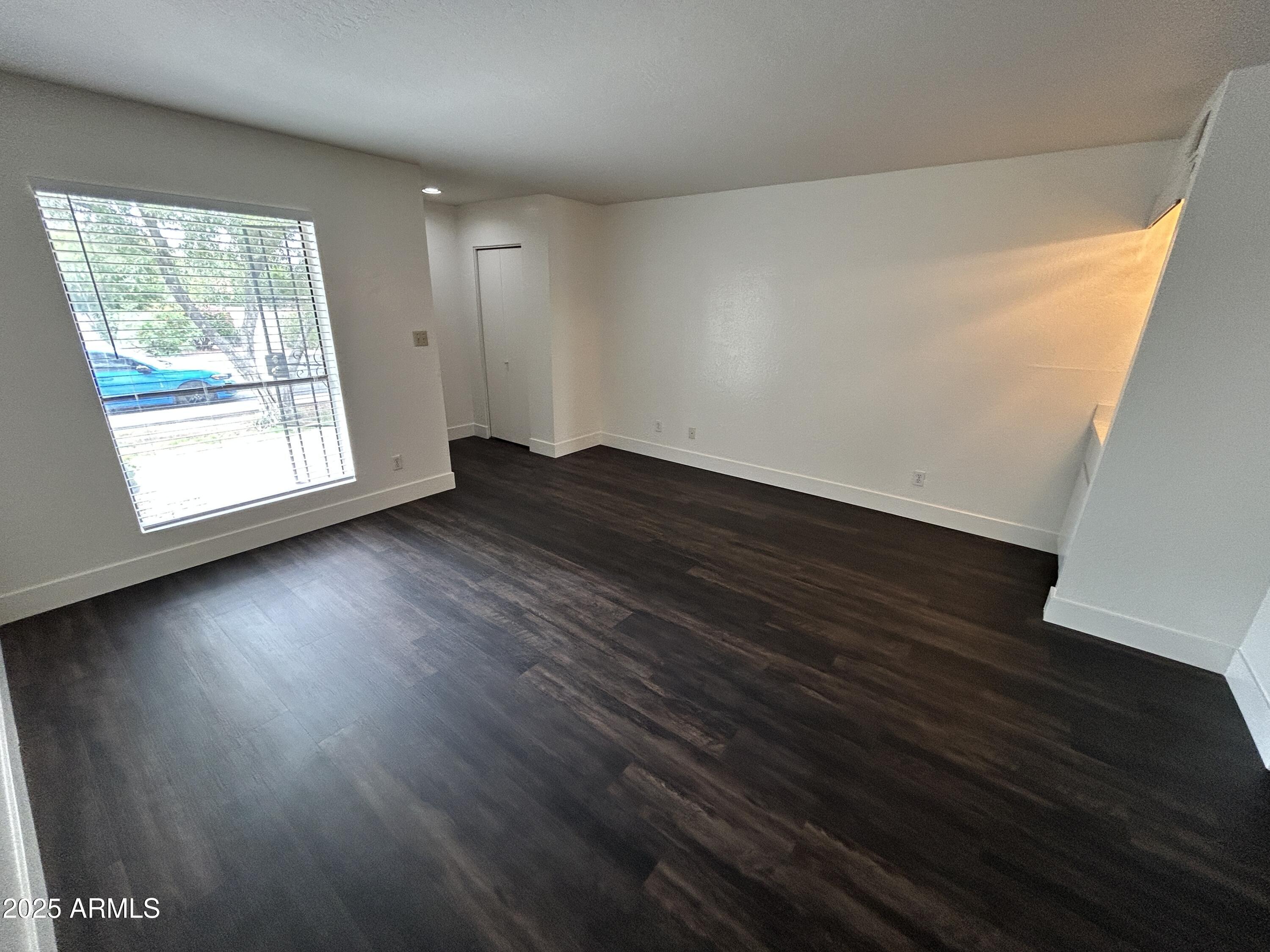 1702 East Ocotillo Road, Unit 2 Phoenix, AZ 85016 - Photo 3 of 18 an empty room with wooden floor and windows