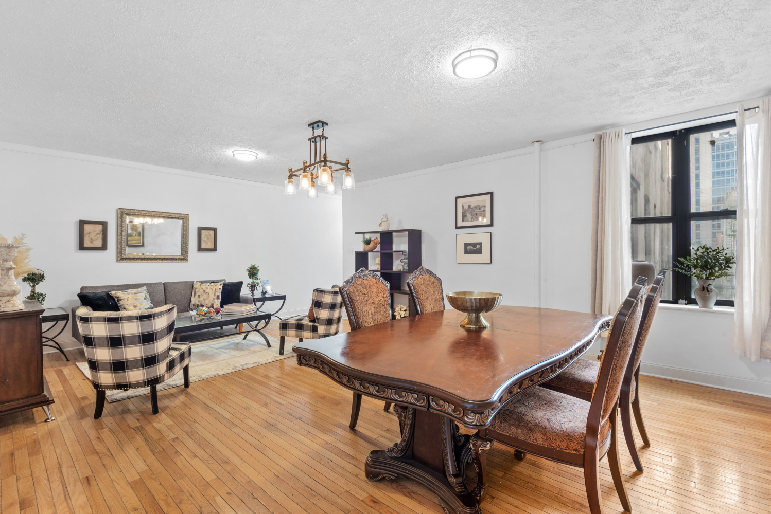 a dining room with wooden floor a chandelier a wooden table and chairs