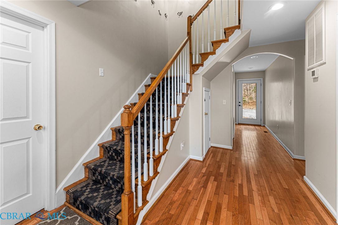 4775 Stormont Road Hartfield, VA 23071 - Photo 38 of 45 Staircase featuring hardwood / wood-style flooring, arched walkways, and recessed lighting