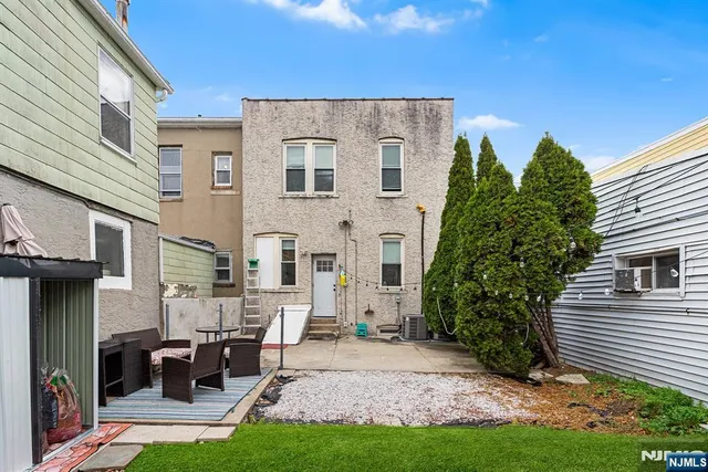 a view of a house with backyard and sitting area