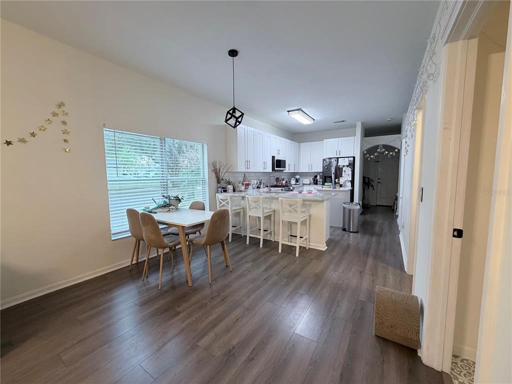 5634 Tanagerlake Road Lithia, FL 33547 - Photo 15 of 46 a view of a dining room with furniture and wooden floor